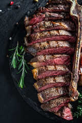 Barbecue dry aged wagyu porterhouse beef steak sliced with large fillet piece. Food recipe background. Close up. vertical image