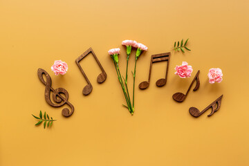 Musical wooden notes with flowers. Top view. Love songs concept