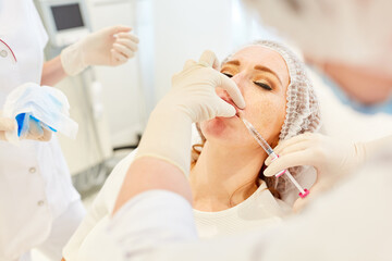Naklejka premium Woman applying hyaluronic acid to her lips