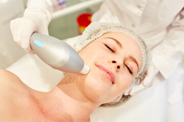 Obraz na płótnie Canvas Woman having skin tightening on her face by ultrasound