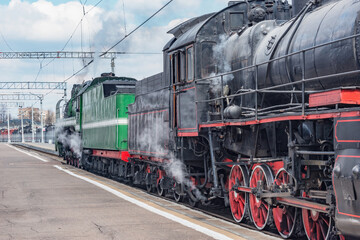 Fototapeta na wymiar Electric and steam trains depart from the station.