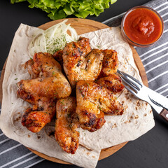 Bbq chicken wings on a wooden board. Top view