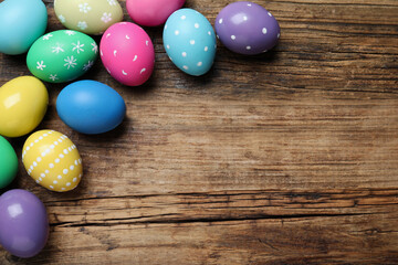 Obraz na płótnie Canvas Colorful eggs on wooden background, flat lay with space for text. Happy Easter