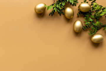 Golden eggs with green tree. Easter decoration background. Top view