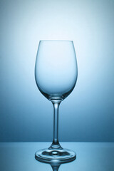 Empty wine glass for white wine on a blue background.