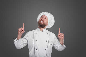 Happy male chef pointing up