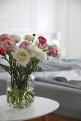 Bouquet of beautiful ranunculuses on table in bedroom