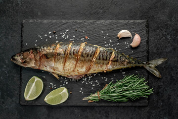 grilled mackerel with lime and spices on stone background