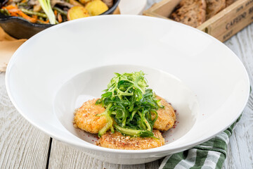 Several chickpea cutlets on a white round plate filmed in decor