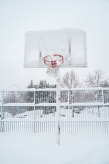 vertical view of frozen basketball outdoors. White conceptual minimalist photo with copyspace. Christmas seasonal cold weather concept.