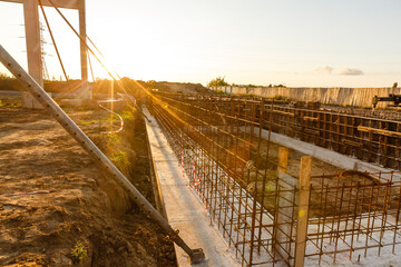 Fototapeta premium Design of reinforcement cage of reinforcement for concrete frame house, brick house, formwork for concrete pouring, construction site, working crane, construction of houses