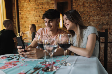 Young couple looking at a smartphone in a restaurant.