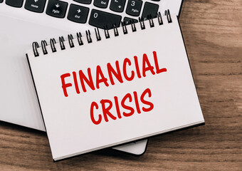 Financial Crisis Concept. Inscription on notepad on laptop keyboard