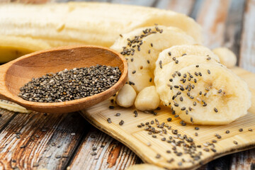 Variety of healthy food concept mockup on the wooden table. Banana and chia on a wooden background close up. Selective focus.