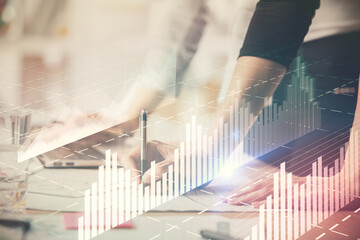 Multi exposure of woman hands typing on computer and financial chart hologram drawing. Stock market...