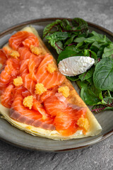 Pancakes with tender fillet of salted salmon with caviar, cheese and herbs. Delicious, hearty, nutritious breakfast. Balanced nutrition for beauty and health.