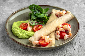 Pancakes with shrimp, cream cheese, guacamole and cherry tomatoes. Delicious, hearty, nutritious breakfast. Balanced nutrition for beauty and health.