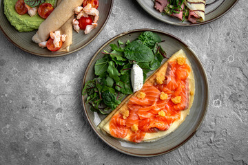 Pancakes with tender fillet of salted salmon with caviar, cheese and herbs. Delicious, hearty, nutritious breakfast. Balanced nutrition for beauty and health.