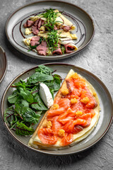 Pancakes with tender fillet of salted salmon with caviar, cheese and herbs. Delicious, hearty, nutritious breakfast. Balanced nutrition for beauty and health.