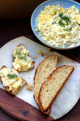 Eiersalat mit Dill angerichtet mit Körnerbrot auf Marmorbrett