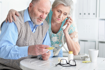 ill Senior couple  at home calling doctor
