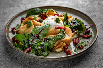 Pancakes with burrata cheese, sun-dried tomatoes, beet leaves and pesto sauce. Delicious, hearty, nutritious breakfast. Balanced nutrition for beauty and health.
