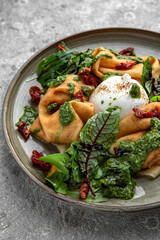 Pancakes with burrata cheese, sun-dried tomatoes, beet leaves and pesto sauce. Delicious, hearty, nutritious breakfast. Balanced nutrition for beauty and health.