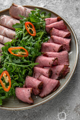 Sliced meat, pastram, beef and pork roll with sauce and salad. Wine appetizer with delicacies.