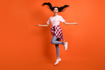 Full size profile portrait of adorable person jump high arms sides open mouth isolated on orange...