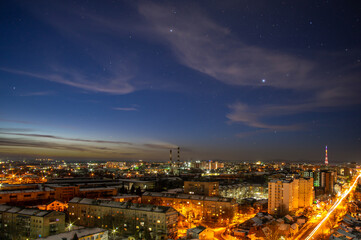 Fototapeta na wymiar Lights of the night city against the background of a beautiful starry sky in Ukraine