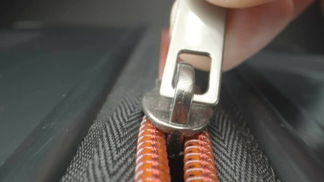 A closer look of the zipper slowly closing the luggage bag 