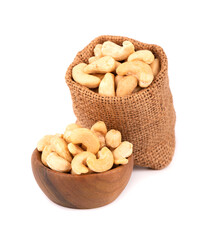 Cashew nuts in bag and wooden bowl, isolated on white background. Roasted cashew nuts.
