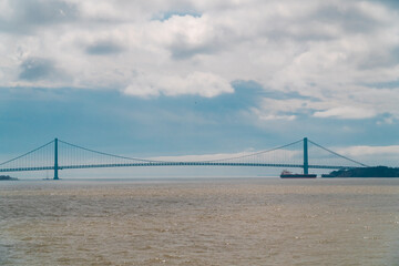 Obraz premium Verrazzano-Narrows Bridge in New York between Staten Island and Brooklyn. Ship under the bridge