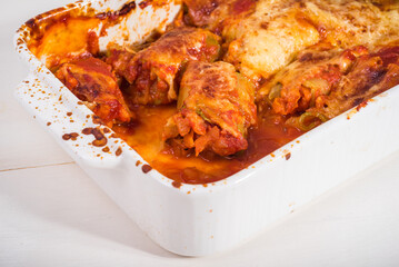Zucchini rolls with vegetable filling baked with cheese in a baking dish close-up