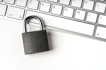 Concept of a computer security. Locked padlock on a white laptop keyboard. 
