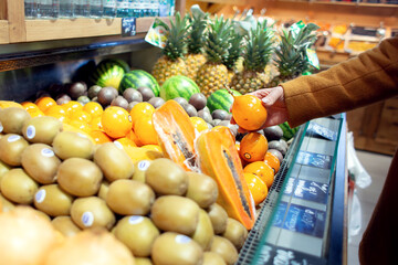 Woman chooses exotic fruits in the store