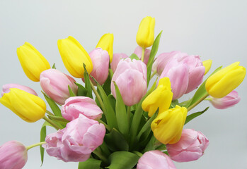 lush bouquet of pink and yellow tulips on a white background