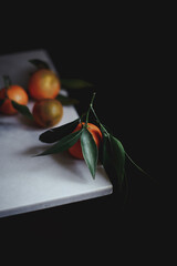 tangerine on a twig with leaves lies on the edge of the table
