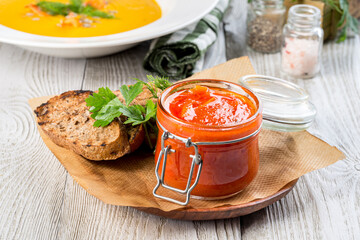 Homemade lecho in a glass jar with a lid filmed in decor