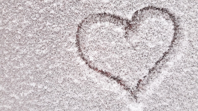 Heart drawn with a finger on the iron surface of hoarfrost. A suitable background of frost on the iron. Copy the space to the left. Heart painted on the surface of frost
