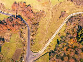 Crossroads on a winding highway in the autumn mountains. View from the drone. Beautiful natural landscape. Carpathians. Ukraine