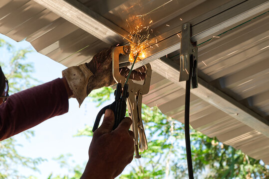 Local Area Skillful Craftsman Welding Roof Top Metal Bar in Construction Site.