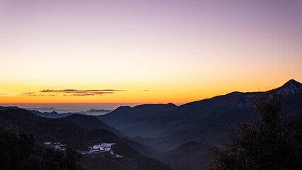Obraz na płótnie Canvas Orange sunrise sky landscape with mountain silhouettes