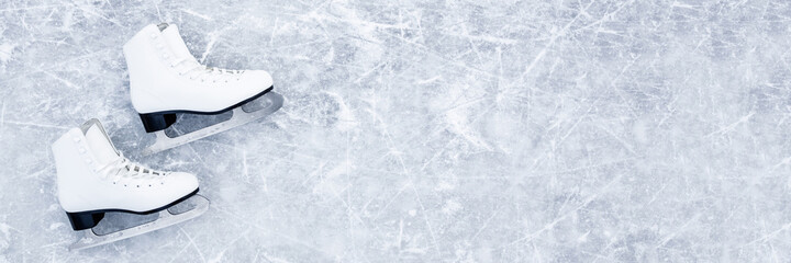White female figure skates on ice background. Sport accessories for outdoor activities in cold...