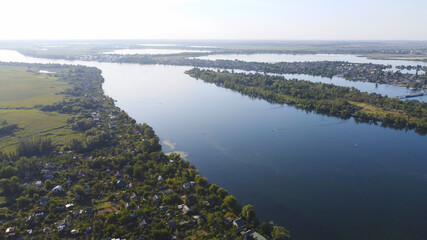 Obraz premium Drone fly over waving river of blue color surrounded by local village with various buildings and Wetland and marsh habitat with a reedbed of Common Reed aerial view.