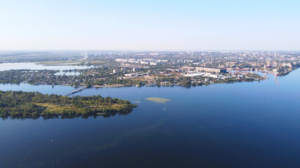 Fototapeta na wymiar Drone fly over waving river of blue color surrounded by local village with various buildings and Wetland and marsh habitat with a reedbed of Common Reed aerial view.