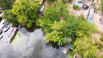 Fototapeta na wymiar Drone fly over waving river of blue color surrounded by local village with various buildings and Wetland and marsh habitat with a reedbed of Common Reed aerial view.