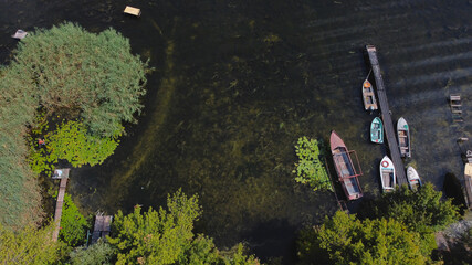 Drone fly over waving river of blue color surrounded by local village with various buildings and Wetland and marsh habitat with a reedbed of Common Reed aerial view.