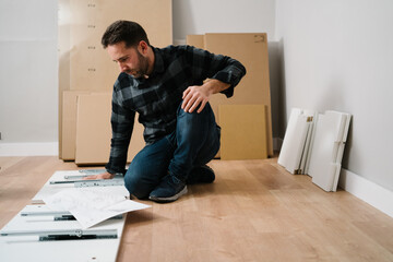 Portrait of man assembling furniture. Do it yourself furniture assembly. - 413225360
