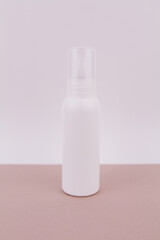 white bottle without an inscription on a light background for perfume or antiseptic gel